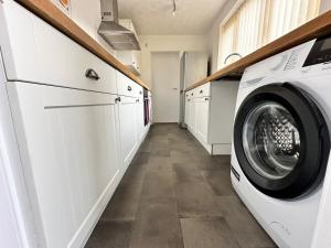 米德尔斯伯勒4 bed 3 bedroom home near Middlesbrough centre的洗衣房配有洗衣机和烘干机