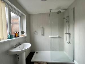 米德尔斯伯勒4 bed 3 bedroom home near Middlesbrough centre的带淋浴和盥洗盆的白色浴室