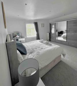 罗奇代尔Spacious Modern Duplex Apartment的一间卧室配有一张大床和镜子