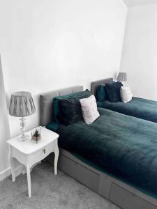 罗奇代尔Spacious Modern Duplex Apartment的一间卧室配有一张床和一张带台灯的桌子