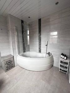 罗奇代尔Spacious Modern Duplex Apartment的一间大浴室,内设一个大浴缸