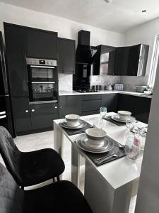 罗奇代尔Spacious Modern Duplex Apartment的厨房配有带盘子和酒杯的桌子