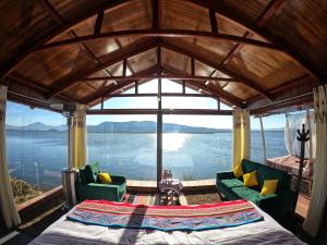 普诺Luna Titicaca Bungalows的客房享有水景,配有1张床和椅子。