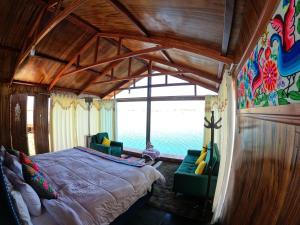 普诺Luna Titicaca Bungalows的一间卧室设有一张大床和一个大窗户