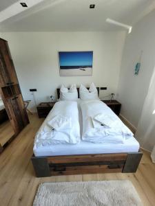 LageExklusive Dorfpension mit Pool und Sauna的配有白色床单和枕头的宿舍间内的一张床位