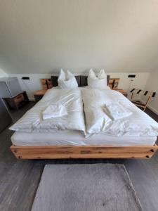 LageExklusive Dorfpension mit Pool und Sauna的一张带白色床单和枕头的床