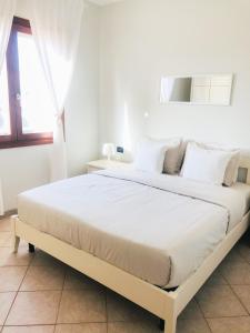 萨尔雷Boavista Beach Apartment的白色卧室配有一张带白色枕头的大床