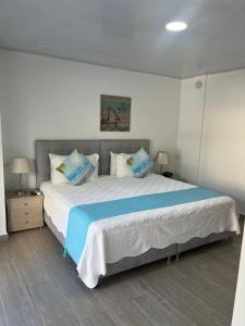 圣安德烈斯Hotel Mar de Corales By CAJASAI的一间卧室配有一张大床,提供蓝色的床单和枕头