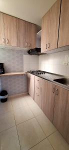 内瓦CB Somos AT HOME Apto cómodo e impecable con Aire Acondicionado的厨房配有木制橱柜和台面