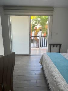 圣安德烈斯Hotel Mar de Corales By CAJASAI的一间卧室设有一张床和一个大型滑动玻璃门