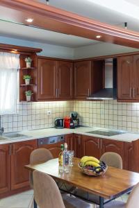 斯加雷塔Amarlia Villa的厨房配有木制橱柜和一张带香蕉的桌子