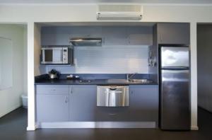 巴特曼斯贝科里甘斯湾酒店的厨房配有不锈钢冰箱和白色橱柜