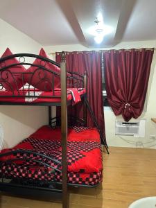 达沃市SEAWIND TOWER 6 CONDOMINIUM的配有红色窗帘的客房内的两张双层床
