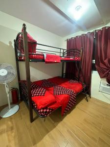 达沃市SEAWIND TOWER 6 CONDOMINIUM的客房设有2张双层床和红色床单