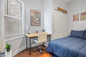 芝加哥Game Day Getaway - 3BR in Vibrant Wrigleyville的一间卧室配有一张桌子、一张床、一张床和一张书桌。