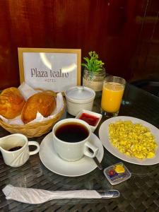齐克拉约Hotel Plaza Teatro的一张桌子,早餐包括咖啡和羊角面包
