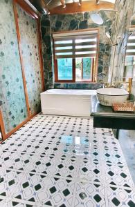 Xuân SơnHang Mua Eco Garden的带浴缸和水槽的浴室以及瓷砖地板。