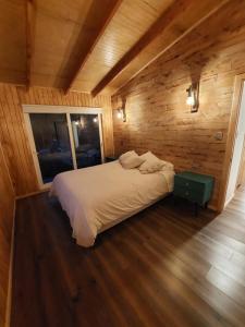 PueloENTRE BOSQUE的木制客房内的一间卧室,配有一张床