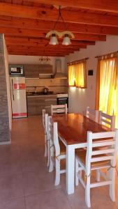 科隆Solar de Artalaz的一间带木桌和白色椅子的用餐室
