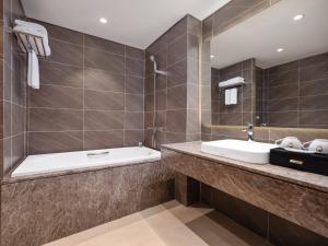 河内Nesta Hotel & Spa的浴室配有盥洗盆和浴缸。