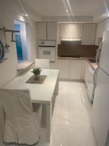 迈阿密海滩Ocean Reserve STR-01045的厨房配有白色橱柜、桌子和冰箱。