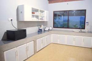 KotmaleVaranda With A View的厨房配有白色橱柜和窗户。