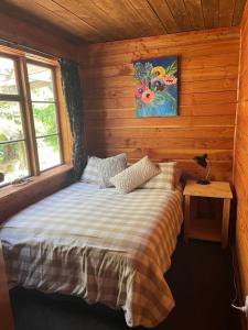 GranityClassic Kiwi bach的小木屋内一间卧室,配有一张床