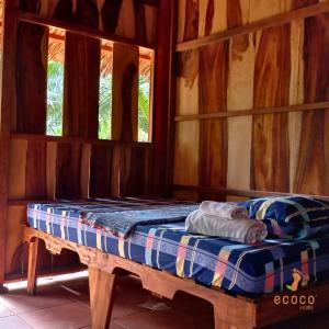槟知Ecoco Homestay Mekong的木间内的一张床位,设有两个窗户
