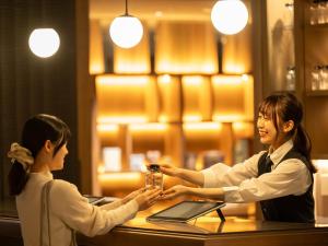京都insomnia KYOTO OIKE的两个女人握手在餐馆的桌子上