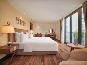 河内Nesta Hotel & Spa的卧室设有一张白色大床和大窗户
