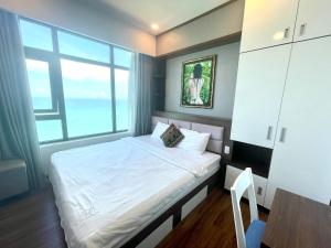 芽庄Muong Thanh Vien Trieu Beachfront Apartment的一间卧室设有一张床和一个大窗户