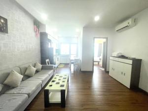 芽庄Muong Thanh Vien Trieu Beachfront Apartment的客厅配有沙发和桌子