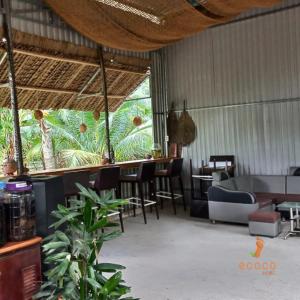 槟知Ecoco Homestay Mekong的餐厅设有桌椅和大窗户。