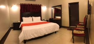 卡拉奇The Elet Business Hotel的一间卧室配有一张大床和镜子