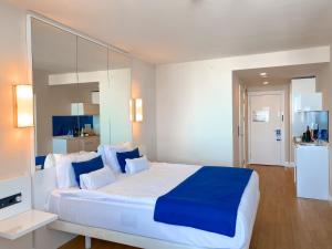 巴统Orbi floor40的一间卧室配有一张带蓝白色枕头的大床
