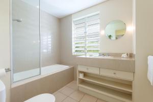 道格拉斯港游廊精品公寓酒店的带浴缸、水槽和镜子的浴室