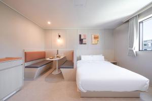 安山市Workers Hotel Ansan by AANK的小房间设有一张床和一张小桌子
