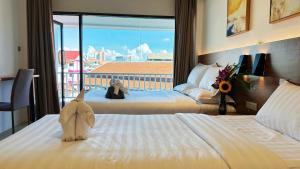 清迈Key酒店@古城中心店的酒店客房,配有两张床,床上有一只动物塞满了东西