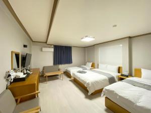忠州市Suanbo Hot Spring Healing Hotel的酒店客房设有两张床和电视。