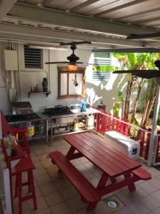 阿雷西博Toda la casa: 3 dormitorios, 4 baños y 1 futón.的厨房在庭院里配有红色野餐桌