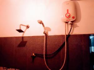 康提Black And White Kandy Guest House 01的浴室设有连接淋浴的软管