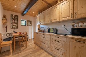 MirnaVineyard Cottage Grajska Kašča - Happy Rentals的厨房配有木制橱柜和桌子。