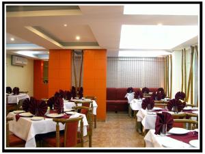 甘德希罕HOTEL GOKUL的一间设有白色桌子和红色墙壁的用餐室