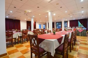 波隆纳鲁沃斯烟科假日度假酒店的餐厅配有桌椅和红色桌布