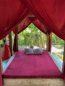 外南梦迪度的住宿加早餐民宿假日公园的红色帐篷内的一张床位,配有粉红色的毯子