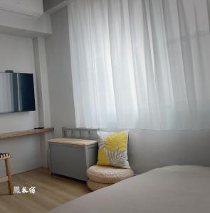 台南鳳米宿Roomi house3的一间卧室配有一张床和一把带枕头的椅子
