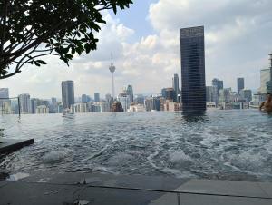 吉隆坡KLCC Suites At Axon Residence的一座城市建筑屋顶上的游泳池