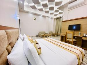 因帕尔Hotel Imolesh Imphal的酒店客房设有一张大床和一张书桌。