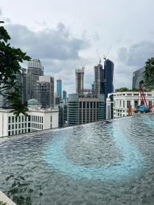 吉隆坡KLCC Suites At Axon Residence的一座城市天际线建筑的顶部游泳池