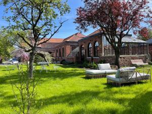 勒藏讷LA PARCELLE的一座绿色庭院,在一座建筑前设有两张沙发